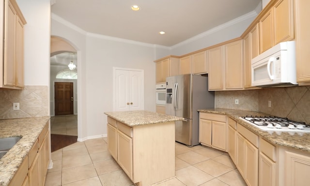 kitchen with a kitchen island, light stone countertops, white appliances, and light tile patterned floors