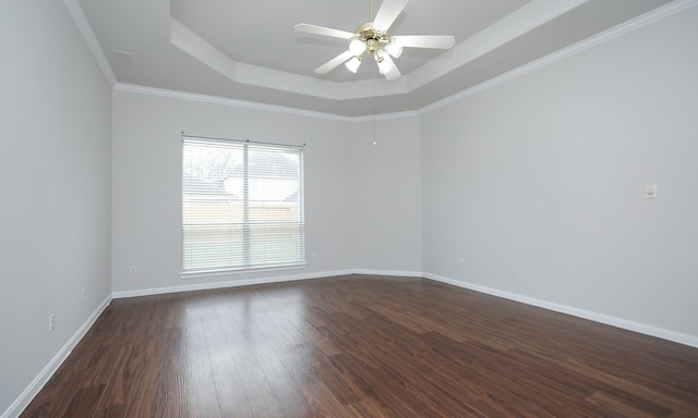 spare room featuring ceiling fan, crown molding, dark wood-type flooring, and a tray ceiling