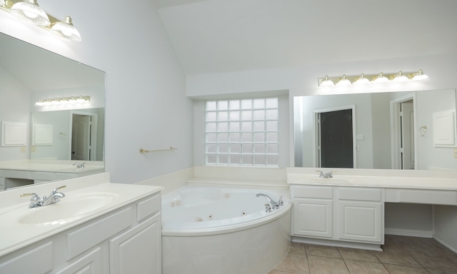 bathroom with tile patterned flooring, vanity, a bathing tub, and lofted ceiling