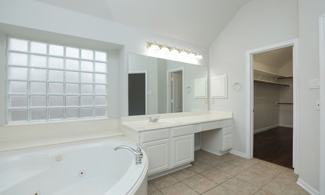 bathroom featuring a bathing tub, tile patterned flooring, vanity, and lofted ceiling