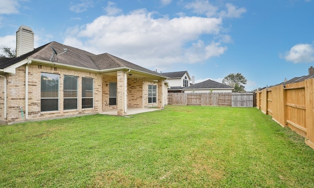 back of house with a lawn and a patio