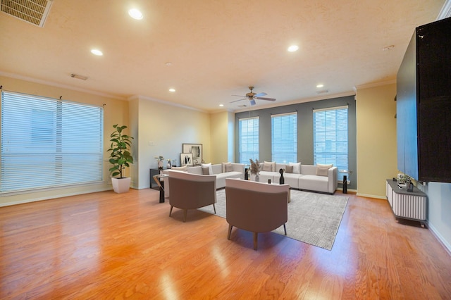 living room with ceiling fan, light hardwood / wood-style floors, and ornamental molding