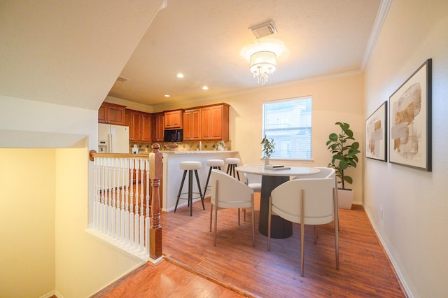 dining room featuring light hardwood / wood-style floors and ornamental molding