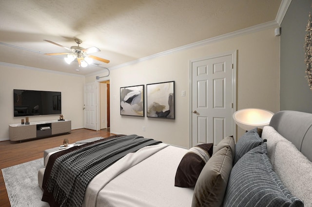 bedroom with hardwood / wood-style flooring, ceiling fan, and crown molding