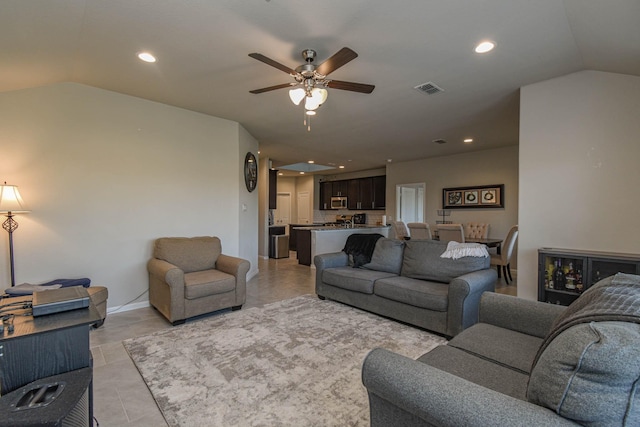 living room featuring ceiling fan and lofted ceiling