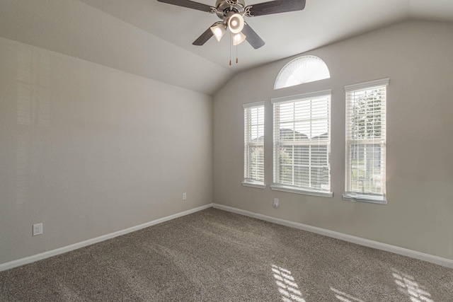 carpeted spare room with ceiling fan and vaulted ceiling