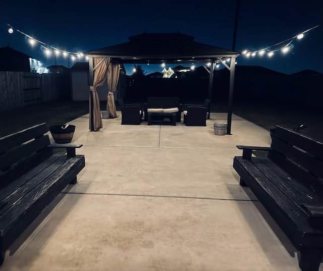 patio at night with a gazebo, a shed, and outdoor lounge area