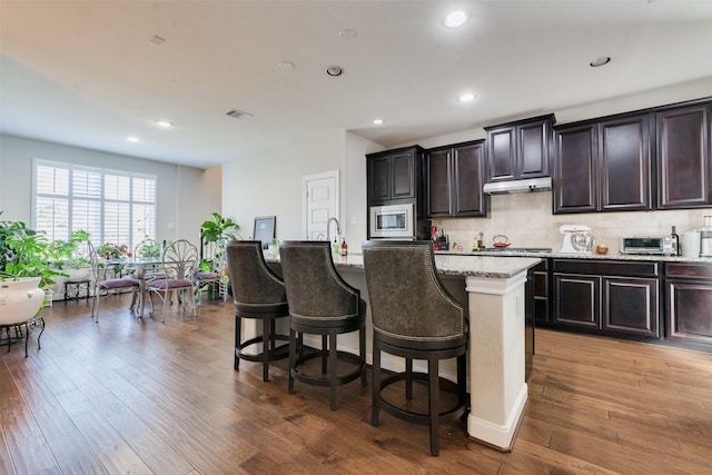 kitchen featuring a breakfast bar, a kitchen island with sink, and appliances with stainless steel finishes