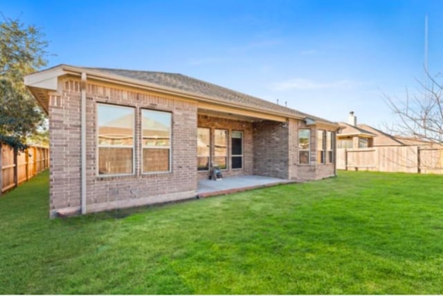 back of house featuring a lawn and a patio