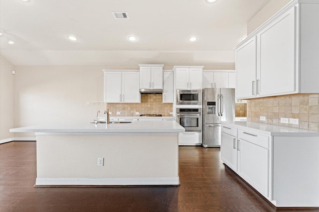 kitchen with white cabinets, sink, an island with sink, appliances with stainless steel finishes, and tasteful backsplash