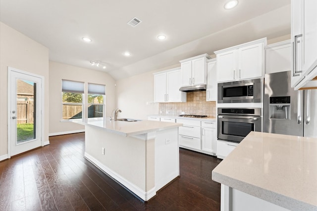 kitchen with lofted ceiling, sink, an island with sink, white cabinetry, and stainless steel appliances