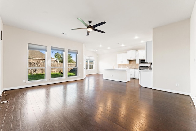 unfurnished living room featuring ceiling fan and dark wood-type flooring