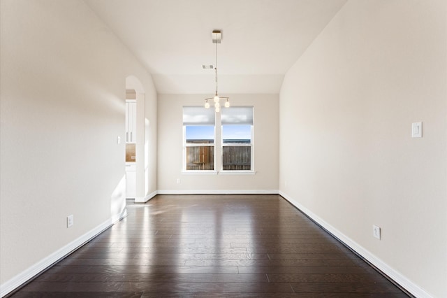 unfurnished dining area featuring vaulted ceiling and dark hardwood / wood-style floors