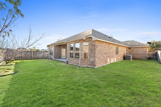 back of house featuring central AC and a yard