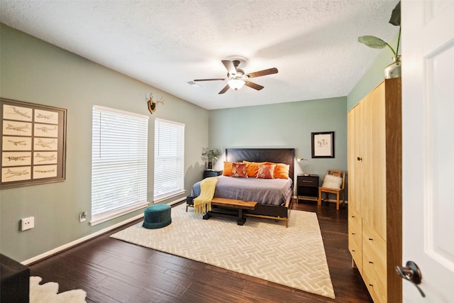 bedroom featuring ceiling fan, dark hardwood / wood-style floors, and a textured ceiling