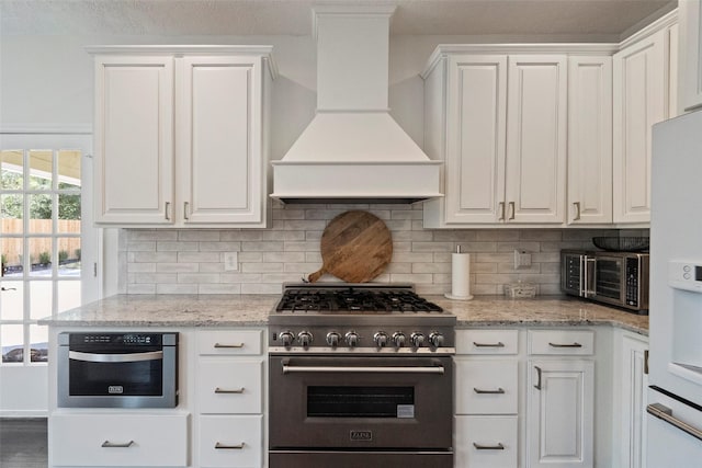 kitchen with white cabinets, custom exhaust hood, and stainless steel appliances