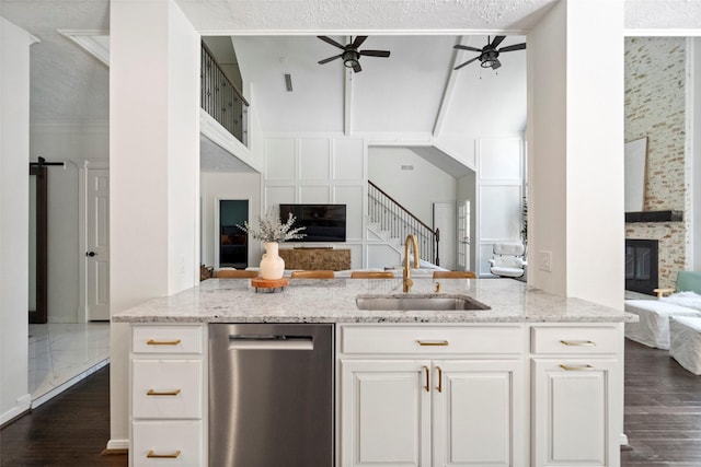 kitchen featuring white cabinets, light stone countertops, and sink