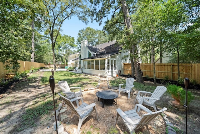 view of yard featuring a fire pit and a sunroom