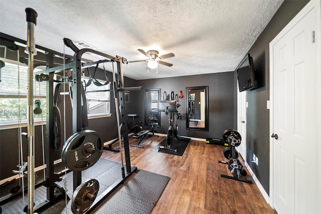 workout area with hardwood / wood-style flooring, ceiling fan, and a textured ceiling