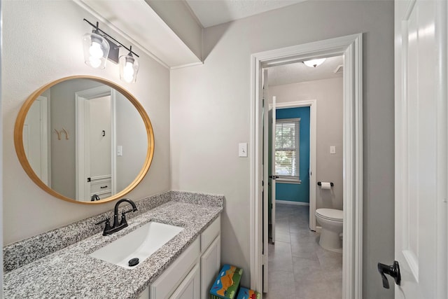 bathroom featuring tile patterned flooring, vanity, and toilet