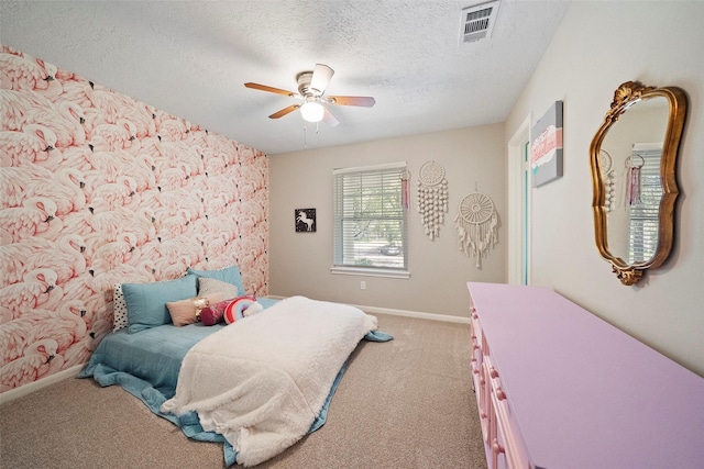 carpeted bedroom with ceiling fan and a textured ceiling