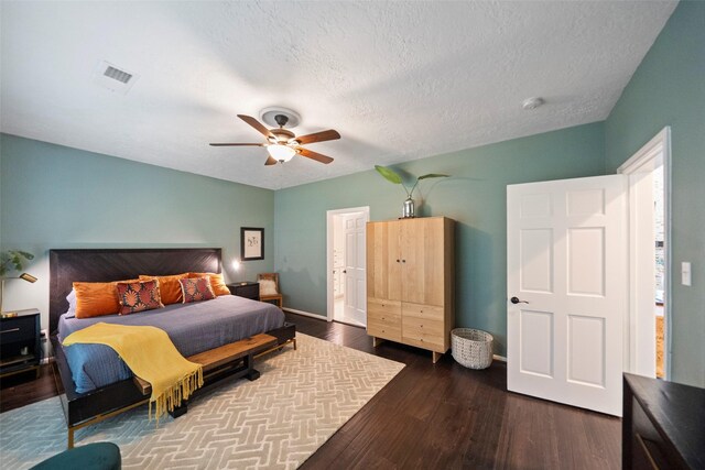 bedroom with a textured ceiling, dark hardwood / wood-style flooring, and ceiling fan