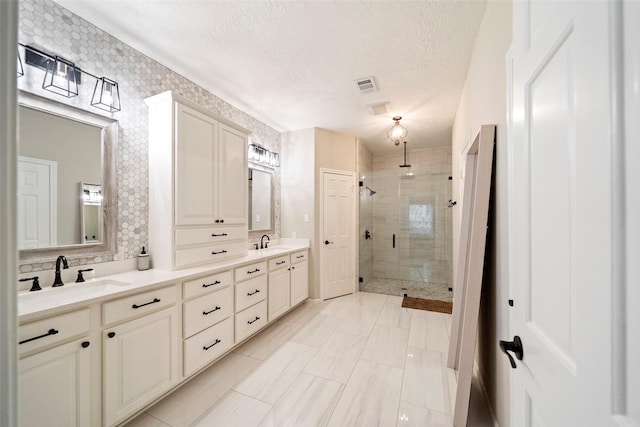 bathroom with vanity, a textured ceiling, and walk in shower