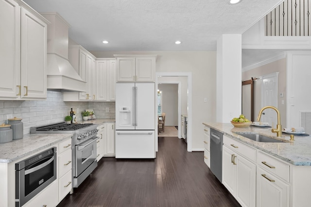 kitchen with high quality appliances, a sink, backsplash, recessed lighting, and white cabinets