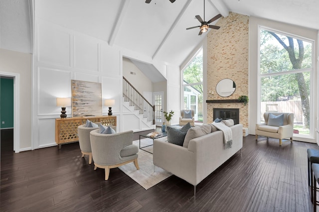 living room with high vaulted ceiling, a ceiling fan, stairway, a fireplace, and beamed ceiling