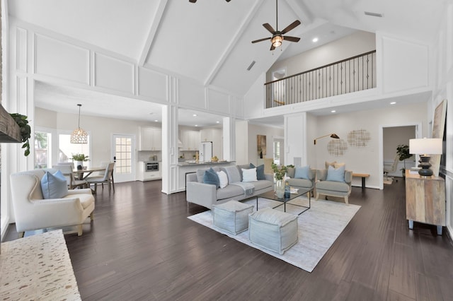 living area with ceiling fan, high vaulted ceiling, beamed ceiling, and dark wood finished floors