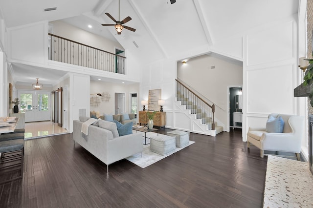 living room featuring stairway, high vaulted ceiling, a ceiling fan, dark wood-style floors, and beam ceiling