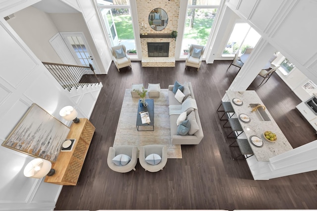 living area featuring a fireplace, plenty of natural light, and wood finished floors