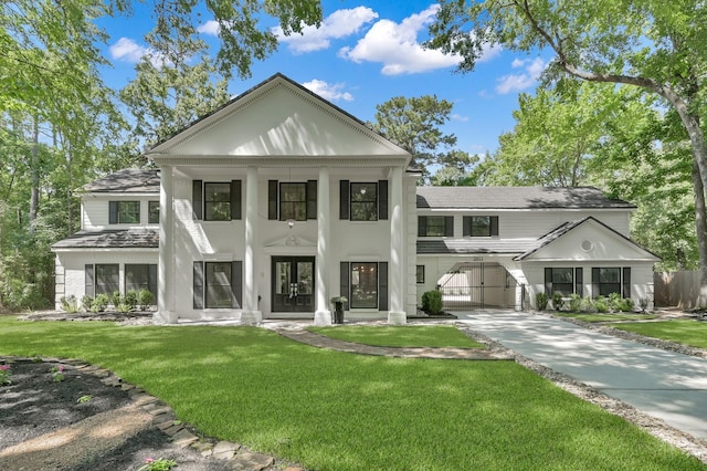 neoclassical home featuring a front lawn, french doors, and concrete driveway