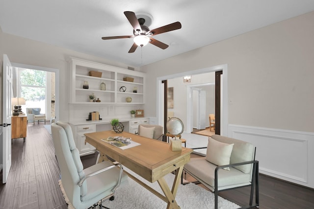 home office with ceiling fan, wainscoting, and dark wood-style floors