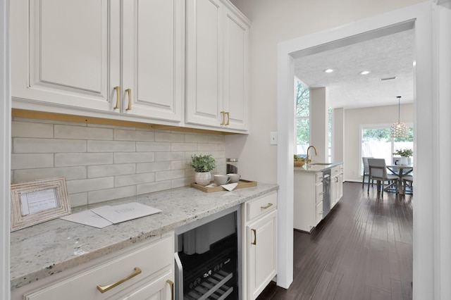 bar with beverage cooler, a sink, tasteful backsplash, dark wood-type flooring, and dishwasher