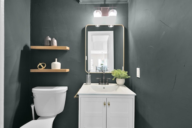 bathroom featuring toilet, vanity, and plenty of natural light
