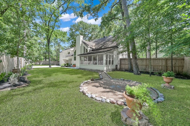 view of yard with a sunroom and a patio area