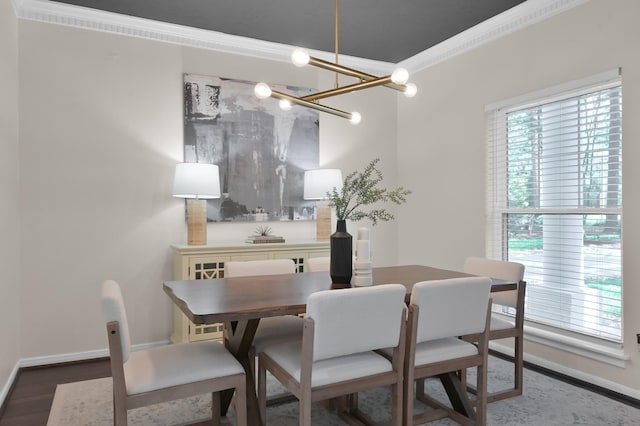 dining area featuring baseboards, a chandelier, crown molding, and wood finished floors