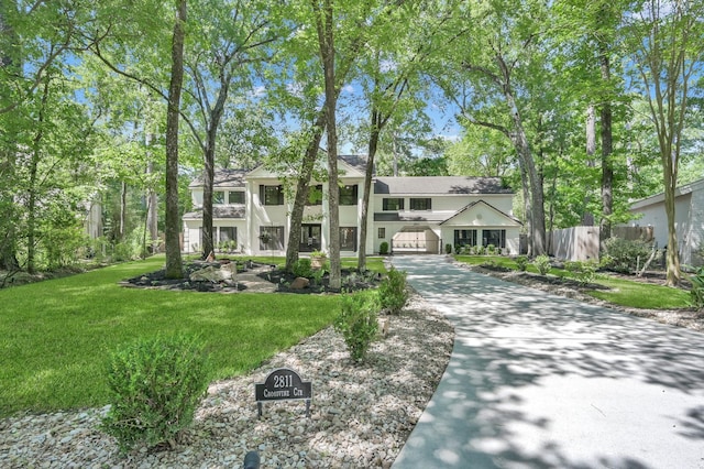 greek revival inspired property with driveway, stucco siding, and a garage