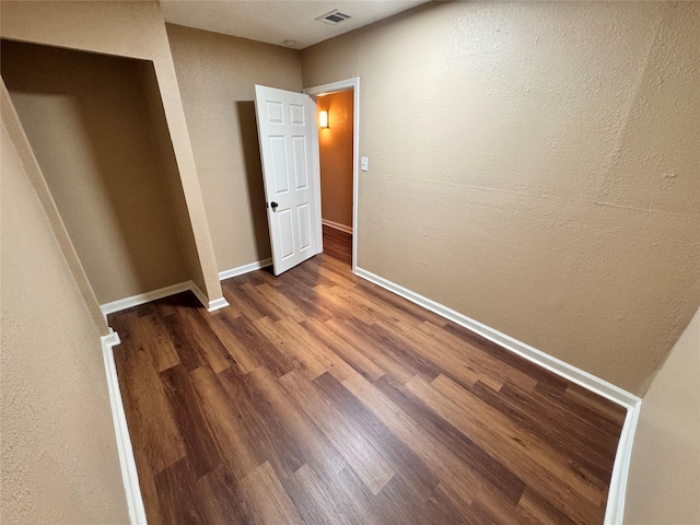 unfurnished bedroom with dark wood-type flooring