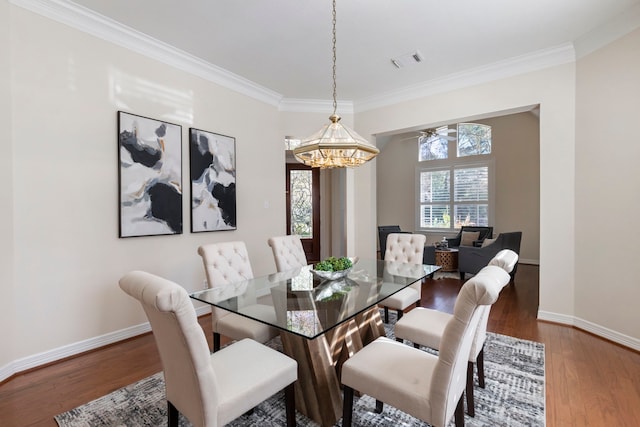 dining room featuring crown molding, ceiling fan with notable chandelier, and hardwood / wood-style flooring