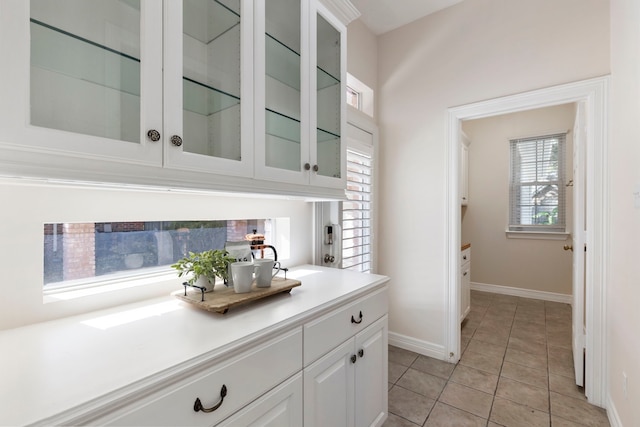 bar with white cabinetry and light tile patterned flooring