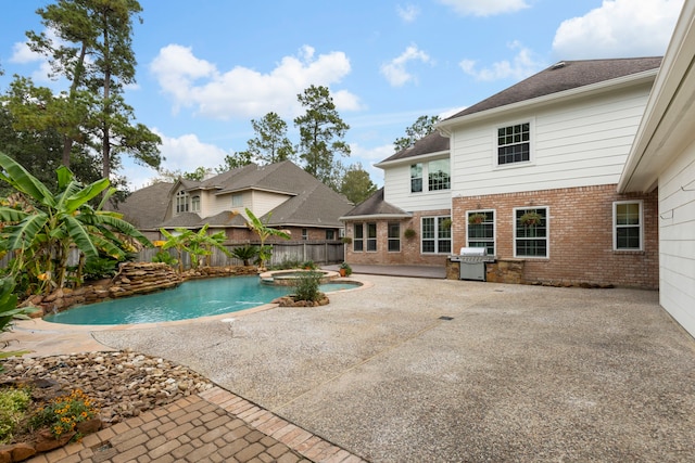 view of swimming pool with an in ground hot tub, a patio, and a grill