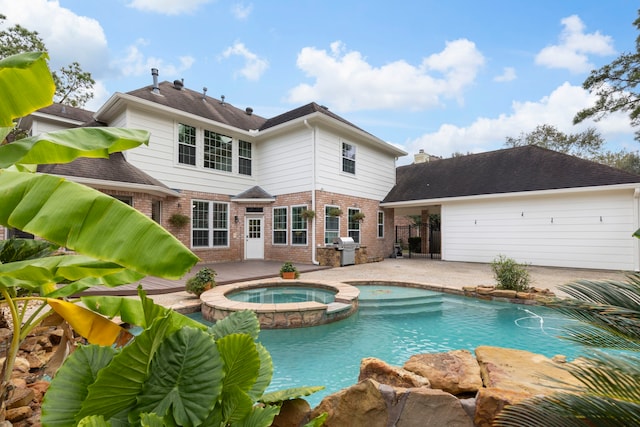 rear view of house with a patio area and a pool with hot tub