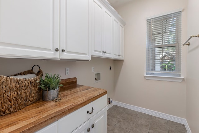 washroom with washer hookup, electric dryer hookup, cabinets, and light tile patterned floors