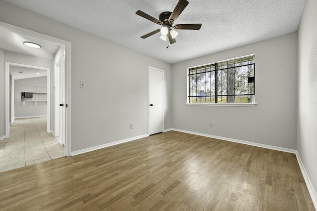 unfurnished bedroom featuring ceiling fan, light hardwood / wood-style flooring, and a textured ceiling