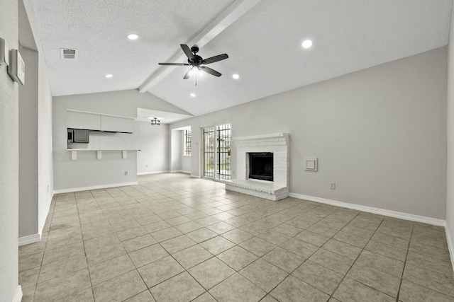 unfurnished living room with ceiling fan, vaulted ceiling with beams, a textured ceiling, a fireplace, and light tile patterned floors