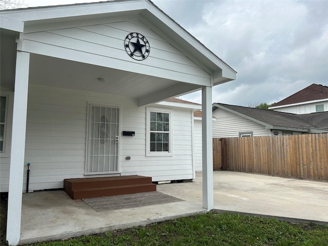 view of exterior entry with a patio area