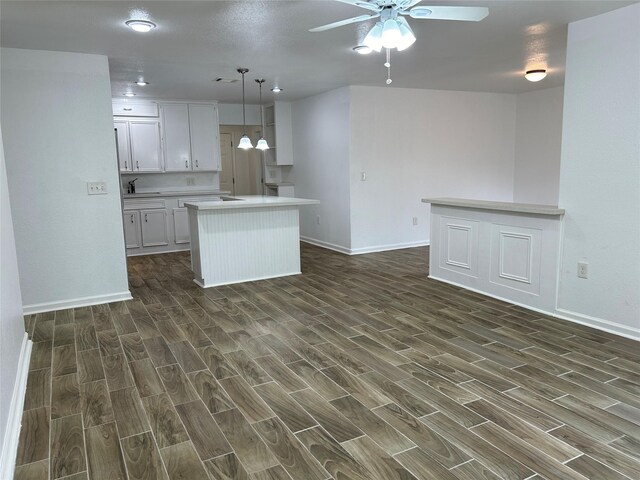 kitchen featuring pendant lighting, a center island, dark hardwood / wood-style floors, and white cabinetry