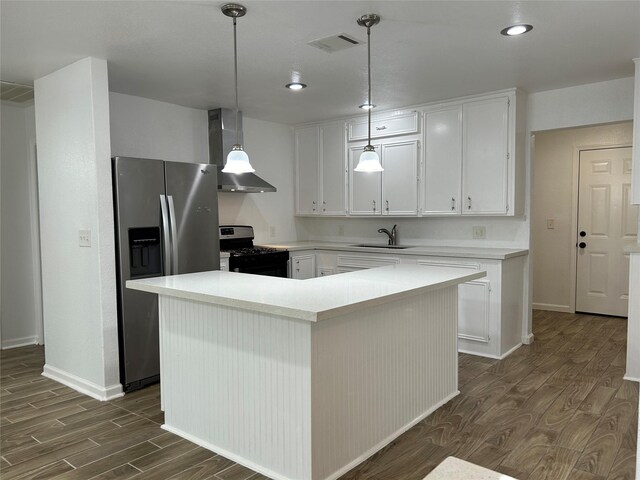 kitchen featuring a center island, wall chimney range hood, stainless steel fridge, white cabinetry, and black range with gas cooktop